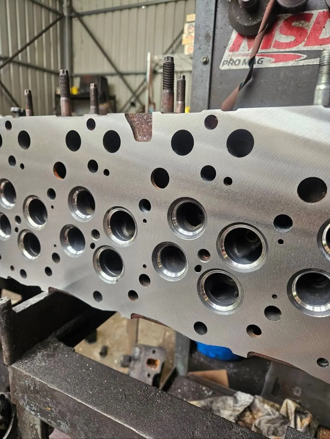 The machined face of a cylinder head showing valve ports and bolt holes.